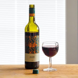 black wine bottle beside clear wine glass